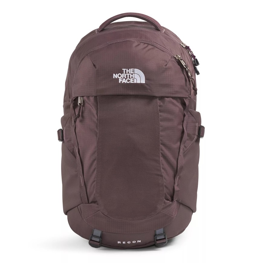 The photo shows a maroon backpack from The North Face, featuring multiple compartments and a top handle. The word \“RECON\“ is visible on the lower part.