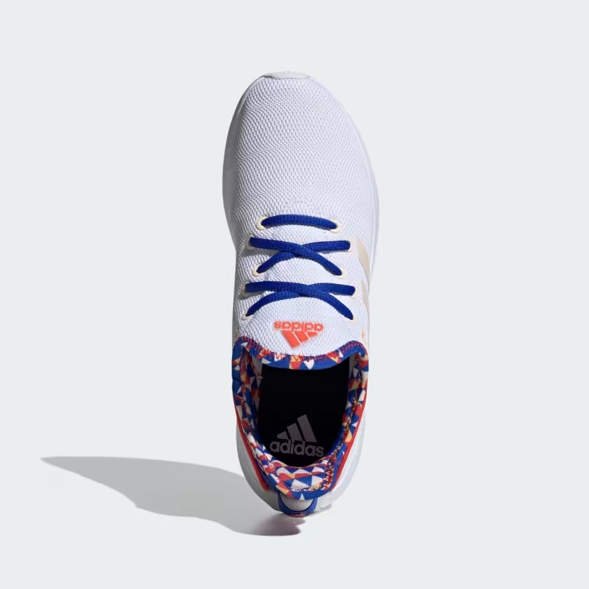 A white Adidas sneaker with blue laces and colorful accents around the shoe opening.