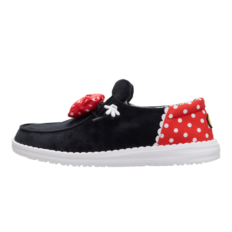 Black shoe with white sole, featuring a red polka-dot bow and accents, plus a small white gloved hand charm.