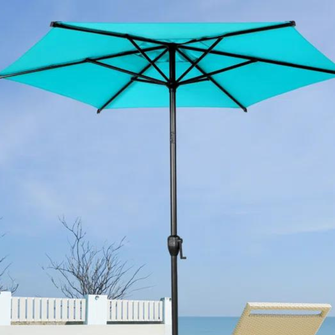 A turquoise patio umbrella with a crank handle, set against a sky backdrop with a glimpse of a sun lounger and white fence.