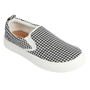 Black and white houndstooth slip-on sneakers with a white rubber sole and pull tab at the back for easy wear.