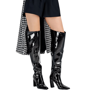 Black patent knee-high boots with block heels, styled with black shorts and a houndstooth-patterned coat.