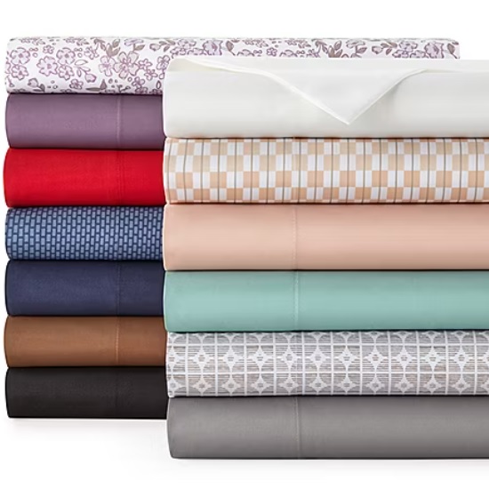 A stack of neatly folded bedsheets in various colors and patterns, including floral, solid, and geometric designs.