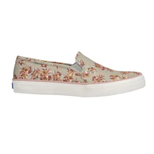 A slip-on canvas shoe with a floral pattern featuring pink and maroon flowers on a beige background, paired with a white rubber sole.