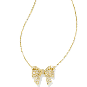 A gold necklace featuring a bow-shaped pendant adorned with sparkling stones and pearls, suspended on a delicate chain.