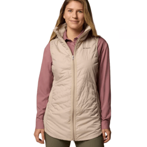 A woman wearing a beige quilted vest over a long-sleeve mauve shirt. The vest has a front zipper and stand-up collar.