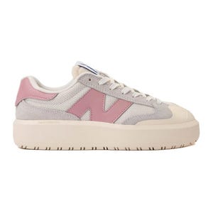 A beige and pink New Balance sneaker featuring a chunky sole, mesh panels, and suede accents.