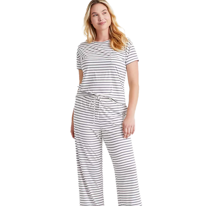 A woman is wearing a comfy 2-piece pajama set featuring a short-sleeve top and drawstring pants with white and black stripes.