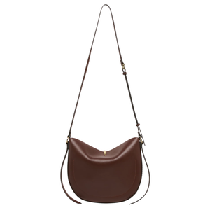A brown leather saddle bag with a long adjustable strap and minimal gold hardware.