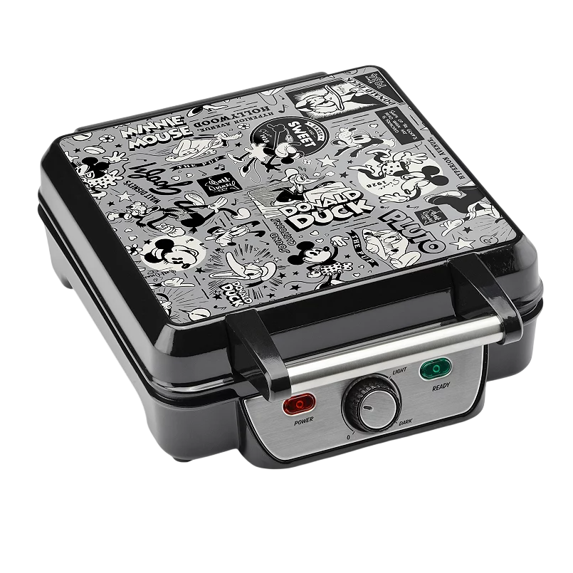 A waffle maker featuring classic Disney characters like Mickey Mouse, Minnie Mouse, Donald Duck, and Pluto in a black and white comic strip design with a power and ready indicator and browning control dial.
