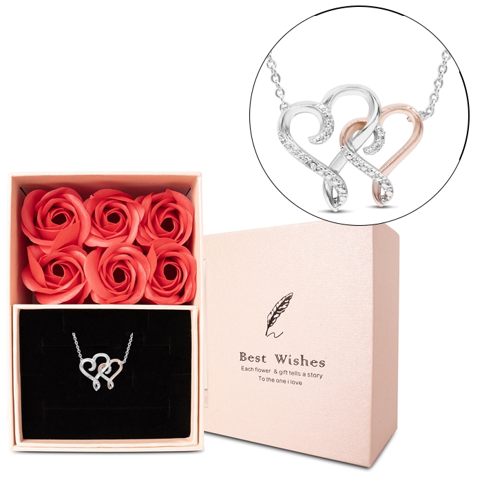 A delicate necklace features intertwined silver and rose gold hearts adorned with small diamonds, paired with a gift box containing six vibrant red faux roses and the words \“Best Wishes.\“