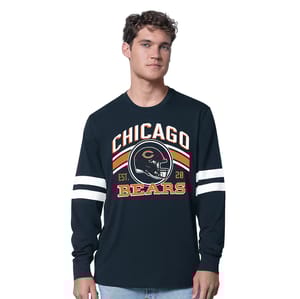 A man models a long-sleeve shirt with \“Chicago Bears\“ graphics and stripes on the sleeves. The shirt features team colors and a logo design.