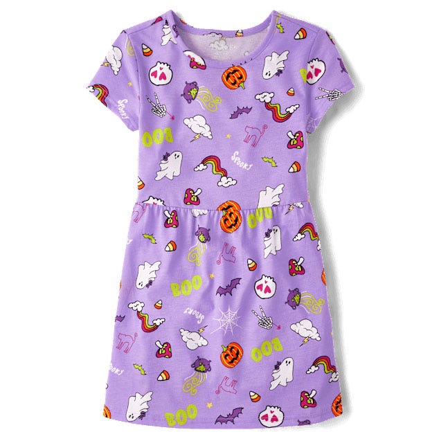 A purple short-sleeve dress featuring playful Halloween-themed patterns, including ghosts, pumpkins, bats, candy corn, rainbows, and the words \“BOO\“ and \“Spooky.\“