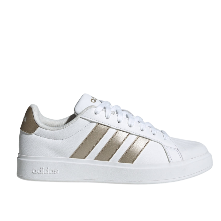 White Adidas sneaker with gold stripes and details, featuring a lace-up design and a low-profile sole.