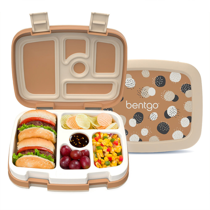 A Bentgo lunch box with multiple compartments holds mini burgers, chips, grapes, sauce, and a mixed vegetable salad, featuring a beige and polka dot design on the lid.