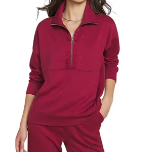 A woman is wearing a red long-sleeve half-zip pullover with a high collar and matching pants.