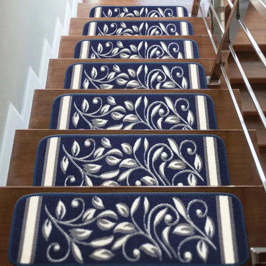 Blue stair treads with white leaf patterns on wooden steps, featuring rounded corners and a stripe on one edge.