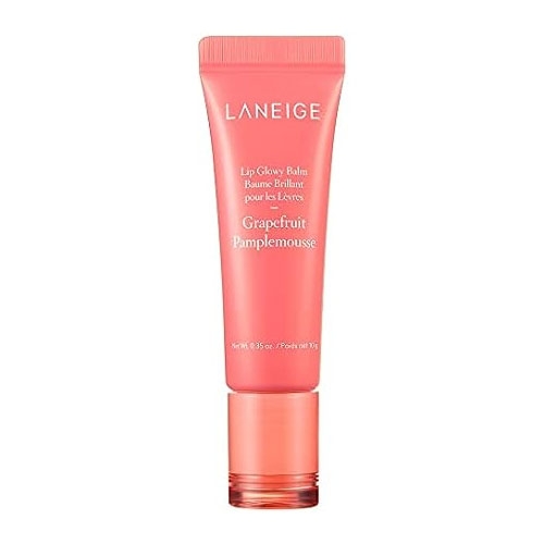 Laneige Glowy Lip Balm in a coral pink tube features a grapefruit scent, noted by \“Pamplemousse\“ on the packaging. The balm is designed to provide hydration and a glossy finish.
