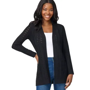 A woman is wearing a black open-front cardigan with a subtle knitted pattern over a white top and blue jeans.