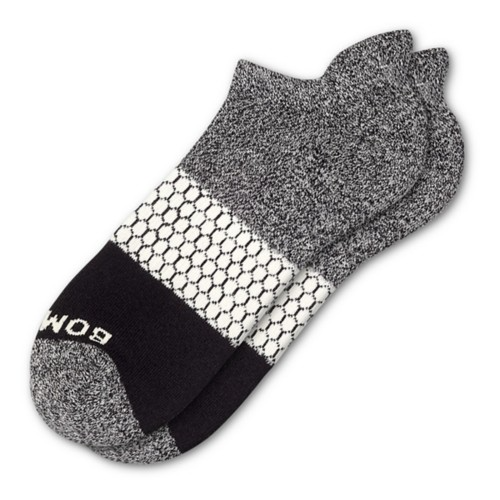 A pair of gray and black ankle socks with a white honeycomb pattern and the word \“BOMBAS\“ on the toe.