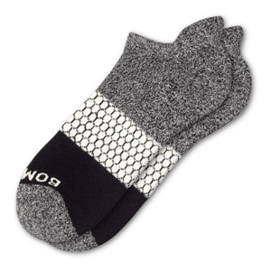 A pair of gray and black ankle socks with a white honeycomb pattern and the word \“BOMBAS\“ on the toe.