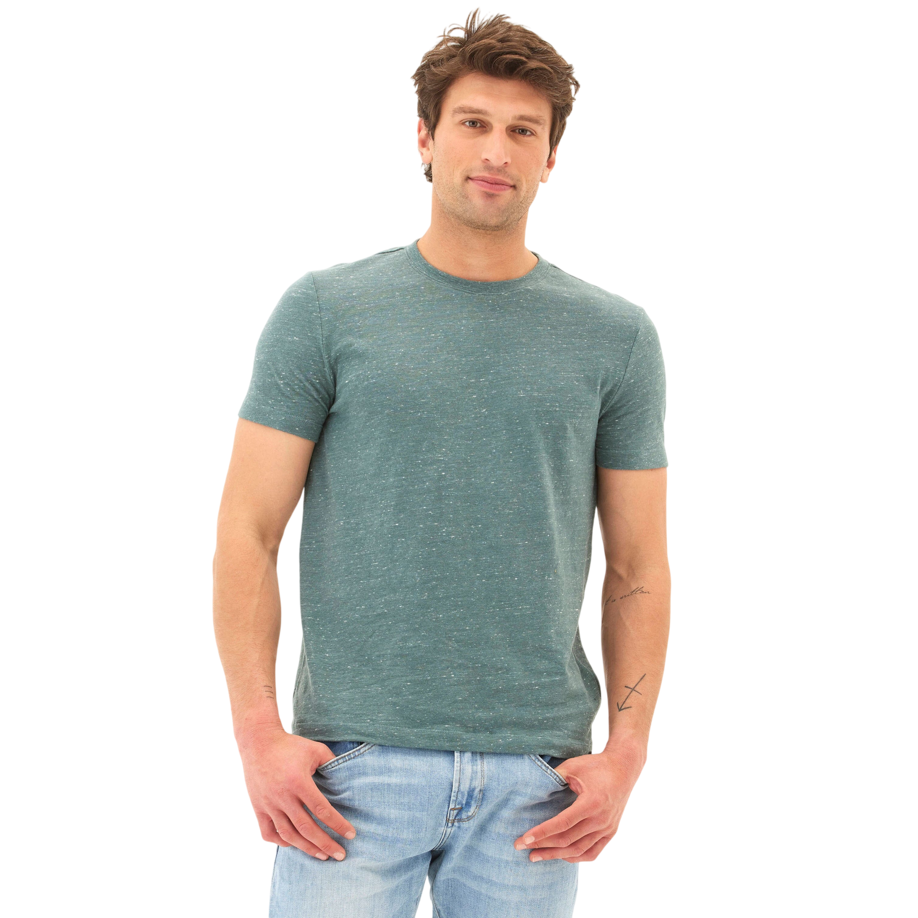 A man is wearing a fitted, short-sleeve, green t-shirt paired with light blue jeans.