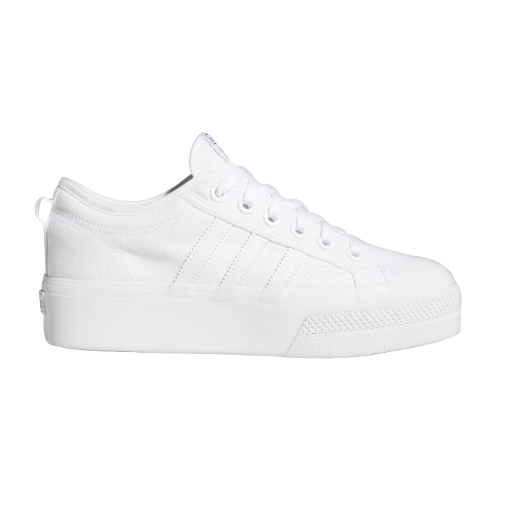 White canvas sneaker with a thick sole, featuring a lace-up design and subtle side stripe detailing.