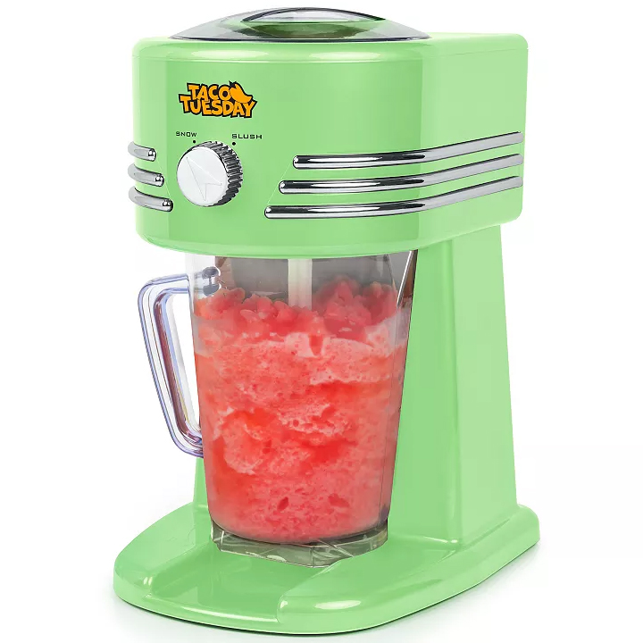 A green slush and shaved ice maker with \“Taco Tuesday\“ branding, featuring a clear pitcher filled with red slush, and a dial for selecting snow or slush settings.