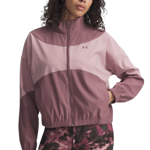 A two-tone pink jacket with a full zip, elastic cuffs, and a stand-up collar featuring the Under Armour logo, paired with patterned leggings.