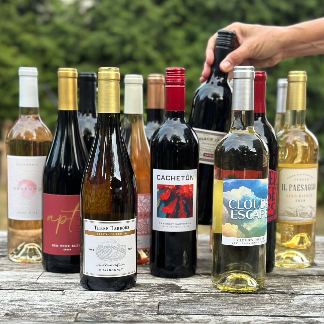 A selection of assorted wines featuring different varieties, including red and white wines, with visible labels like \“Three Harbors Chardonnay,\“ \“Cachetón Cabernet Sauvignon,\“ \“Cloud's Escape Sauvignon Blanc,\“ and \“Il Paesaggio Vino Bianco.\“