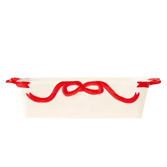 White ceramic baking dish with red ribbon design, featuring two handles.