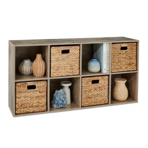 Six-cube organizer with wooden finish includes woven storage baskets and decorative ceramic vases, along with books and other decor items.