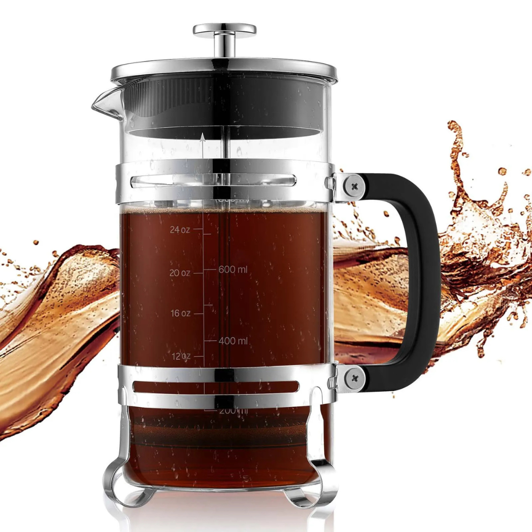 A French press coffee maker with a transparent glass body, stainless steel frame, and black handle, showing measurement markings. It's filled with coffee against a splash background.