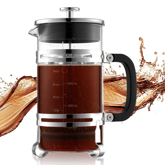 A French press coffee maker with a transparent glass body, stainless steel frame, and black handle, showing measurement markings. It's filled with coffee against a splash background.