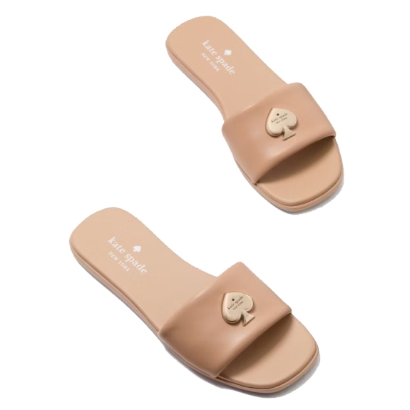 Pair of beige slide sandals with a spade logo on the strap, branded \“Kate Spade New York.\“