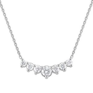 A delicate necklace featuring a row of seven sparkling, round-cut stones set in a symmetrical pattern on a fine chain.