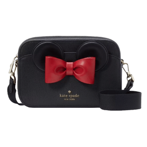 Kate Spade Disney Minnie Mouse Camera Bag features black leather, Minnie Mouse ear accents, a red bow, a detachable strap, and gold-toned hardware with the Kate Spade logo.