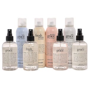 A collection of Philosophy body spritzes and dry shampoos, including scents like Baby Grace, Fresh Cream, Amazing Grace, and Pure Grace, are displayed in spray and aerosol bottles.