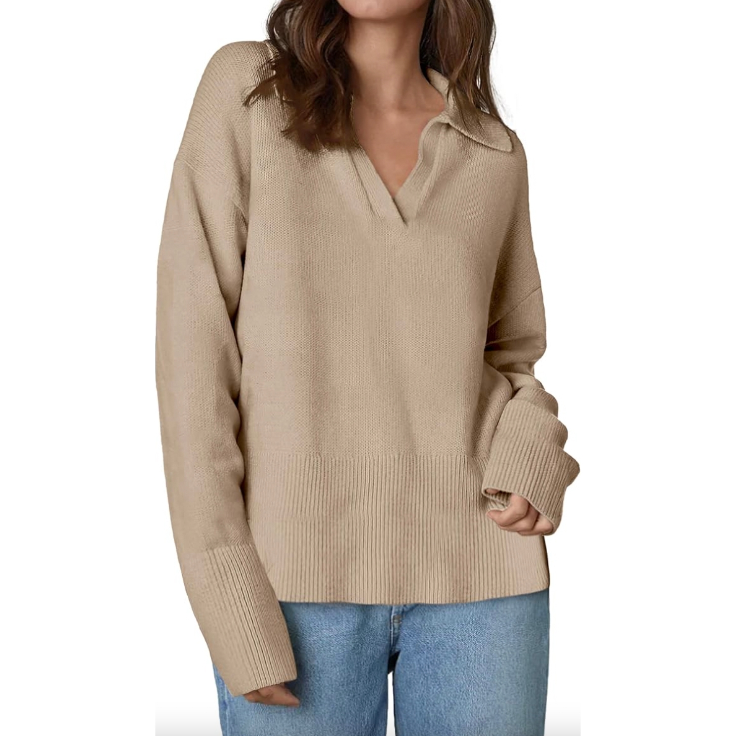 Woman wearing a beige v-neck sweater and blue jeans.