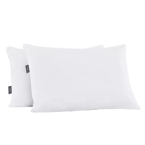 Two white pillows with a subtle pattern and small brand tags on the side.