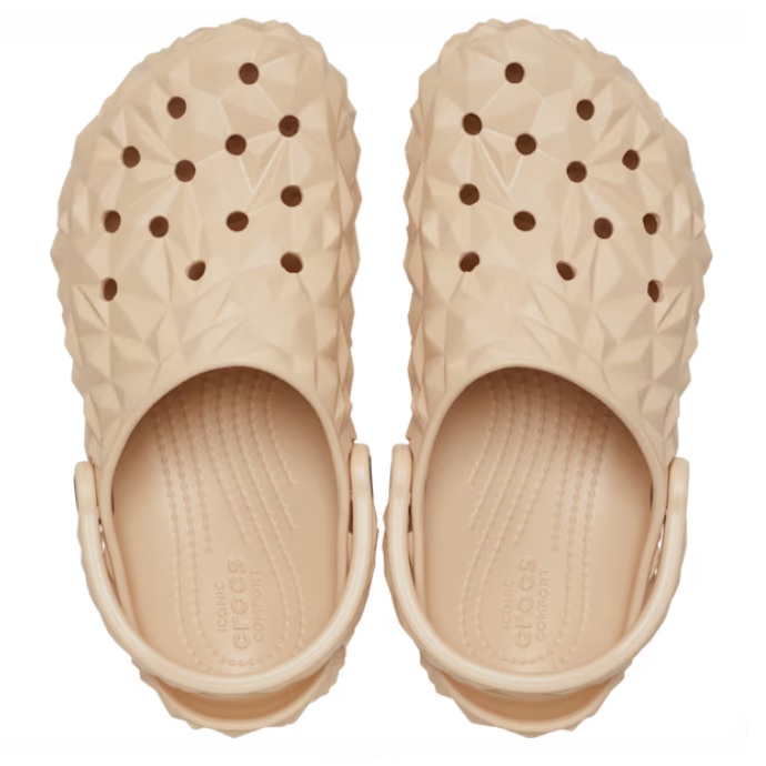 Beige Crocs Classic Geometric Clogs featuring a textured diamond pattern on the upper part and the brand's signature holes for breathability.