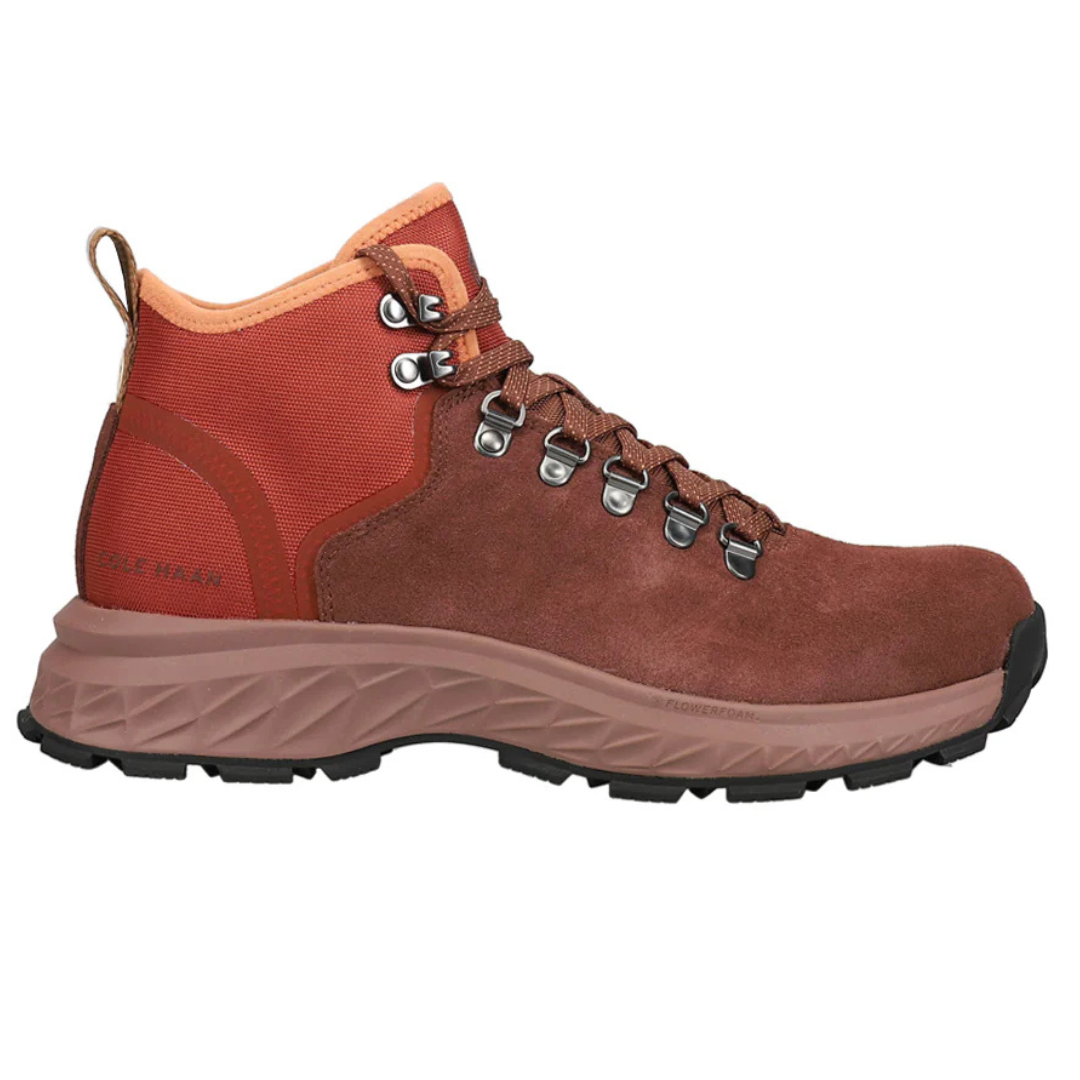 Cole Haan hiking boots feature a brown suede and fabric upper, metal eyelets with hiking-style laces, a padded ankle collar, and a rugged, textured outsole for traction.