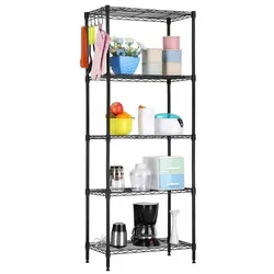 A black metal shelving unit holds various items, including kitchen utensils, storage containers, a coffee maker, a blender, and a bowl of fruit, with additional utensils hanging on the side.