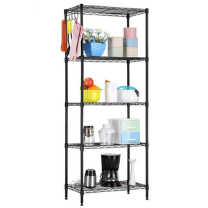 A black metal shelving unit holds various items, including kitchen utensils, storage containers, a coffee maker, a blender, and a bowl of fruit, with additional utensils hanging on the side.