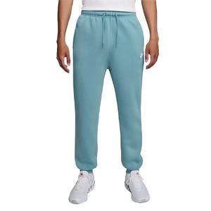 Light blue joggers with an elastic waistband, drawstring, and small white logo on the left thigh. Paired with white sneakers.