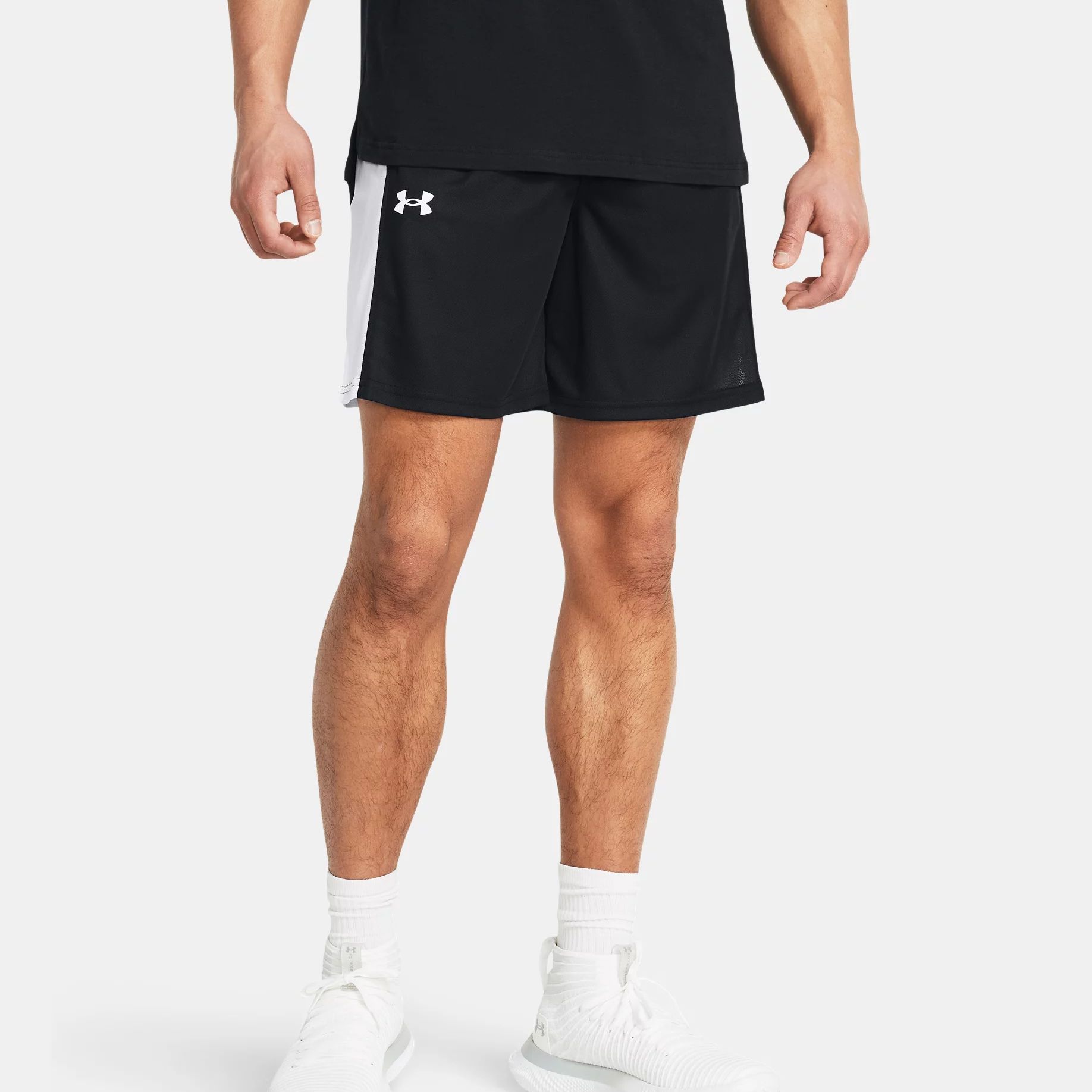 A man wearing black athletic shorts, white socks, and white sneakers.
