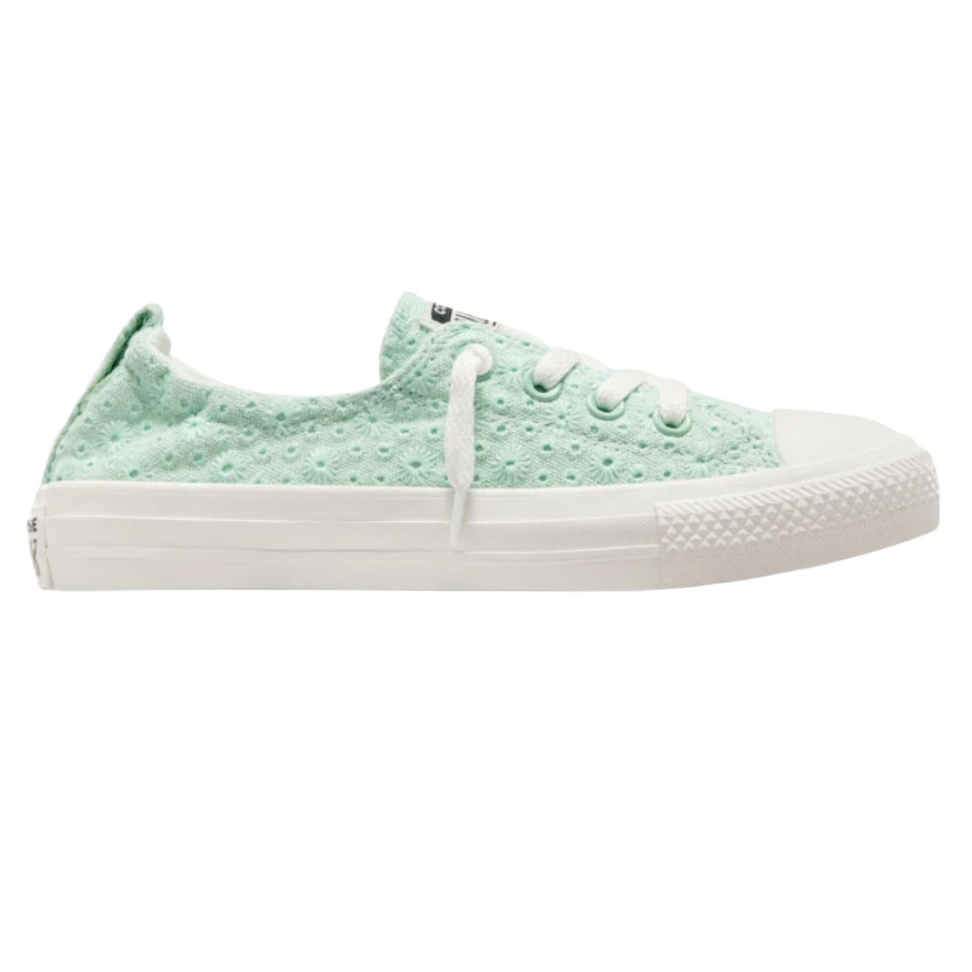 Mint green low-top sneaker with a textured floral pattern, white laces, and a white rubber sole.