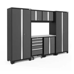 A modular garage storage system featuring tall cabinets, upper storage units, a central workbench, drawers with wheels, and additional side cabinets.