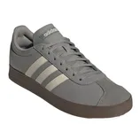 Gray Adidas sneakers featuring three white stripes and a brown sole, with laces and a logo on the tongue.