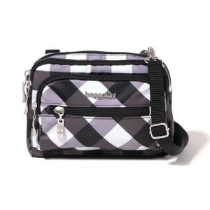 A small crossbody bag with a black-and-white checkered pattern and multiple zip compartments.